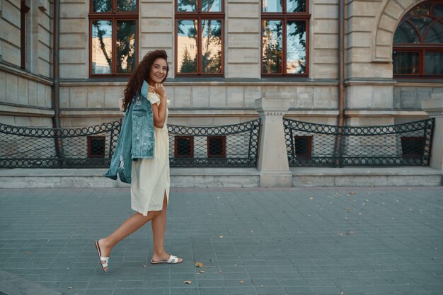 Portret van stijlvolle lachende, gelukkig brunette vrouw lopen op straat