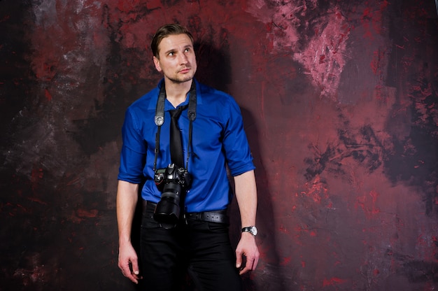 portret van stijlvolle professionele fotograaf man met camera, draag op blauw shirt en stropdas.