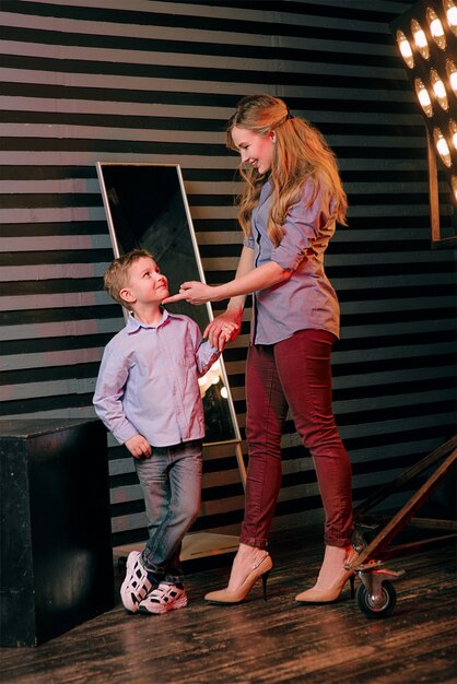 portret van stijlvolle schattige kleine jongen met mooie moeder in fotostudio