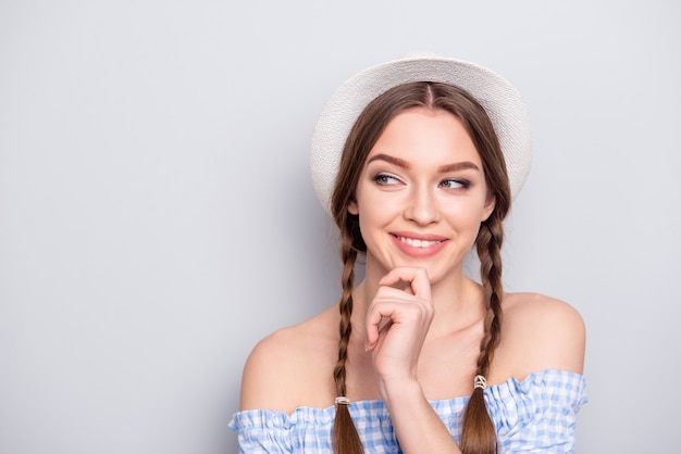 Portret van stijlvolle vrouw met vlechten poseren tegen de grijze muur