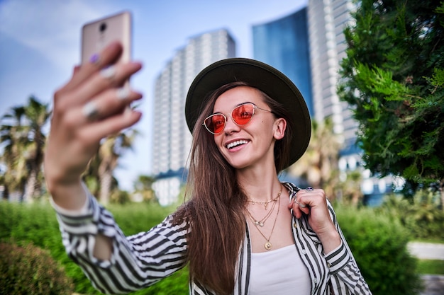 Portret van stijlvolle zorgeloze hipster vrouw met vilten hoed en felrode bril