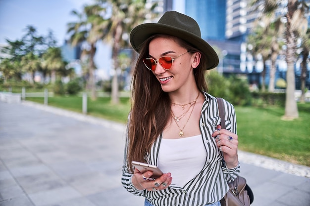 Portret van stijlvolle zorgeloze hipster vrouw met vilten hoed en felrode bril