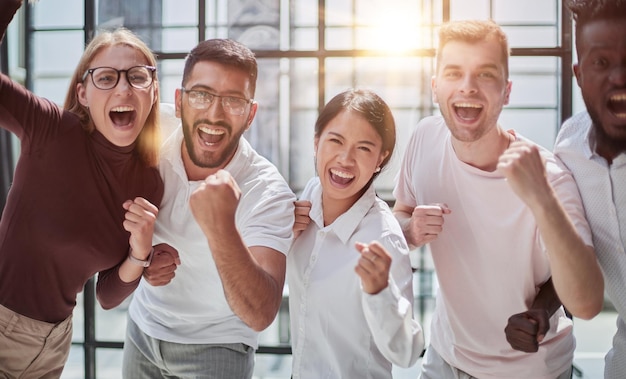 Portret van succesvol creatief commercieel team dat camera en het glimlachen bekijkt