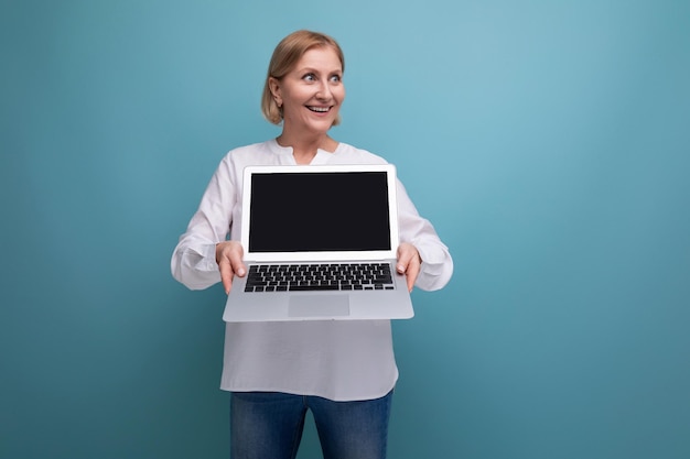 Portret van succesvolle volwassen zakenvrouw met blond haar met laptop met schermsjabloon