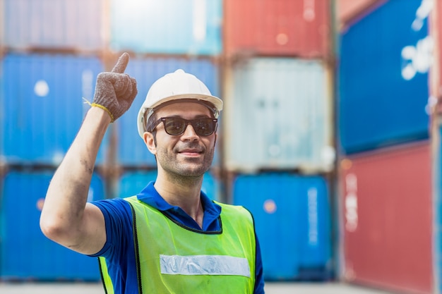 Portret van succesvoorman die scheepvaart latijns-stafarbeider werkt in de vrachthaven voor import-exportgoederen staande glimlach met zonnebril.