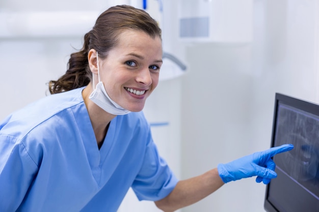 Portret van tandartsassistent die een röntgenstraal op de monitor onderzoekt