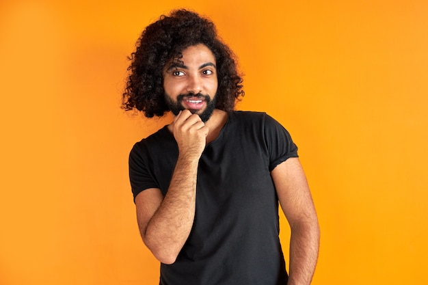 Portret van tevreden Arabische man geïsoleerd in de studio, knappe jongen in vrijetijdskleding poseren