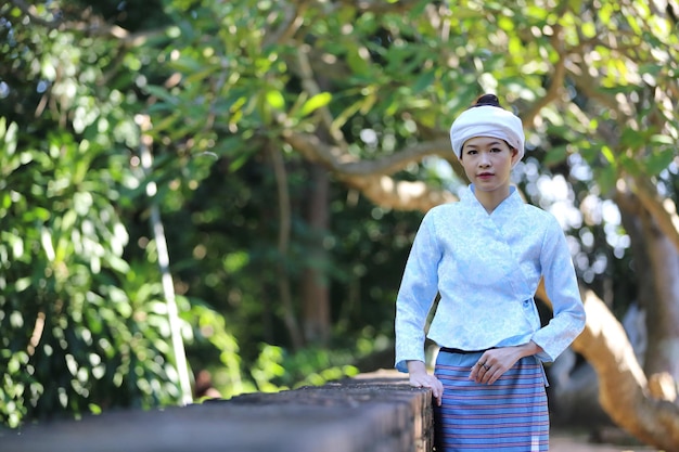 Portret van Thaise jonge vrouw met traditionele Thaise kleding in Thaise tempel met boom en zonsopgang