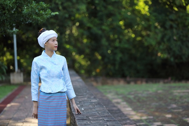 Portret van Thaise jonge vrouw met traditionele Thaise kleding in Thaise tempel met boom en zonsopgang