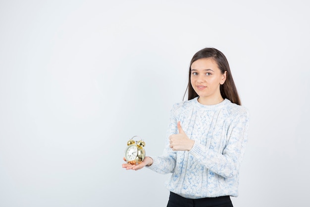 Portret van tienermeisje in de wekker van de sweaterholding.