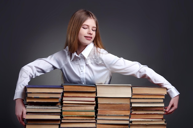 Portret van tienermeisje met stapels boeken