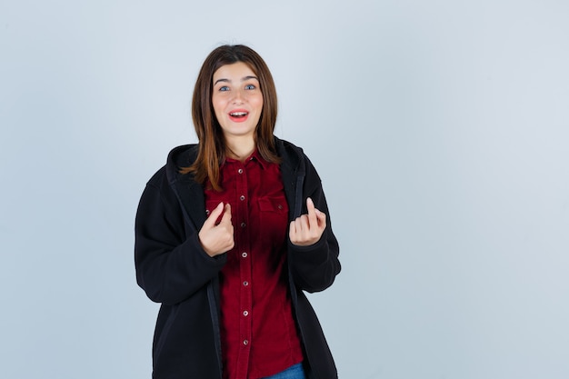 Portret van tienermeisje wijzend naar zichzelf in shirt, jas en verbaasd vooraanzicht