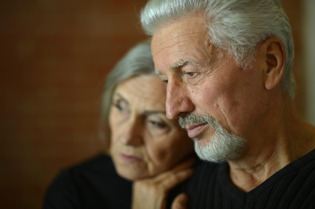 Foto portret van triest senior koppel dat thuis poseert