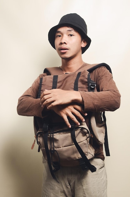 Portret van trieste Aziatische jonge man met rugzak voor reizen geïsoleerd op achtergrond