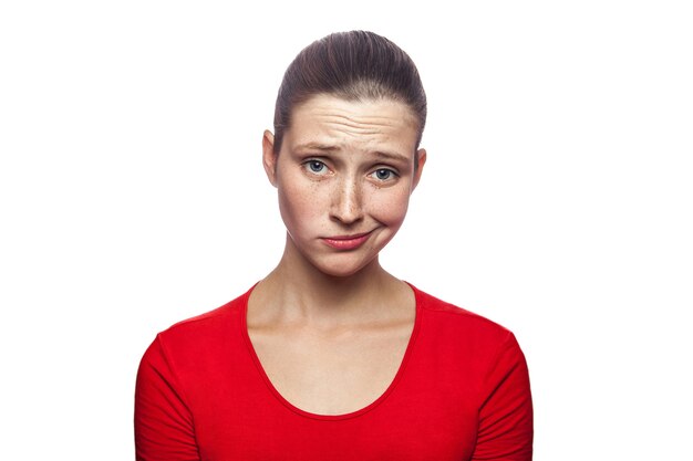 Portret van trieste ongelukkige vrouw in rode t-shirt met sproeten studio shot