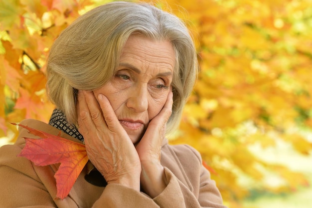 Portret van trieste senior mooie vrouw in herfstpark