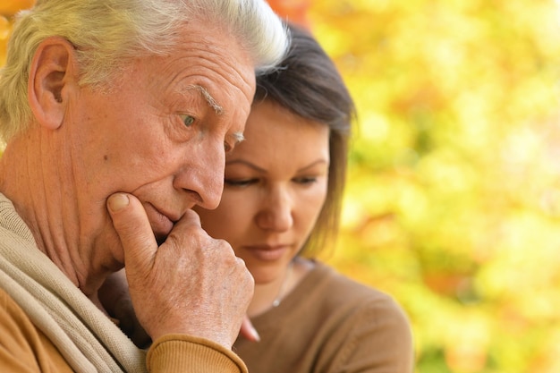 Portret van trieste vrouw en senior man knuffelen