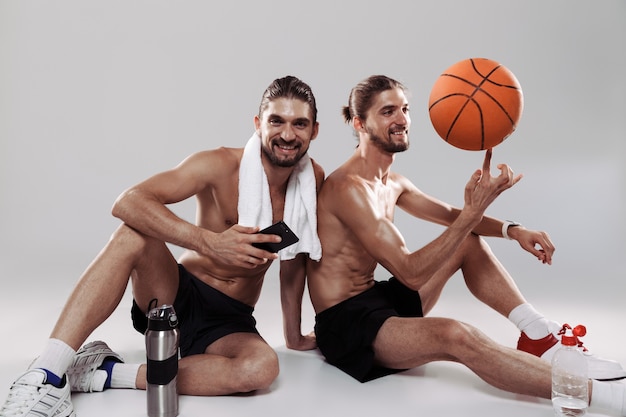 Portret van twee gelukkige, gespierde tweelingbroers zonder shirt