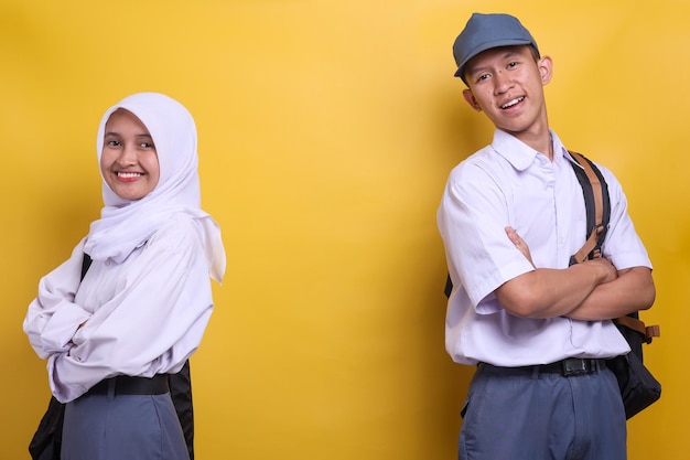 Portret van twee Indonesische middelbare scholieren in wit en grijs uniform met kopieerruimte op geel