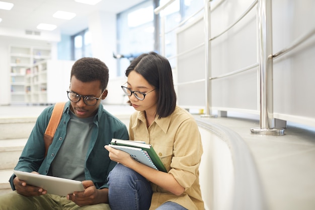 Portret van twee internationale studenten die samen boeken lezen