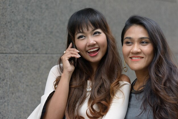 Foto portret van twee jonge aziatische ondernemers samen in de stad buiten