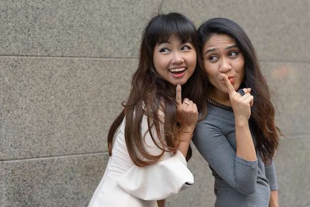 Portret van twee jonge Aziatische ondernemers samen in de stad buiten