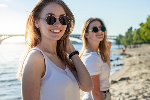 Portret van twee jonge mooie meisjes op het strand