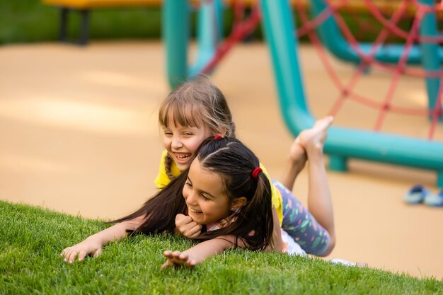 Portret van twee kleine meisjeszusters die vechten op de achtertuin van het huis. Vrienden meisjes plezier. Lifestyle openhartig familiemoment van broers en zussen die ruzie maken om samen te spelen.