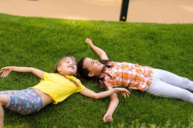 Portret van twee kleine meisjeszusters die vechten op de achtertuin van het huis. Vrienden meisjes plezier. Lifestyle openhartig familiemoment van broers en zussen die ruzie maken om samen te spelen.