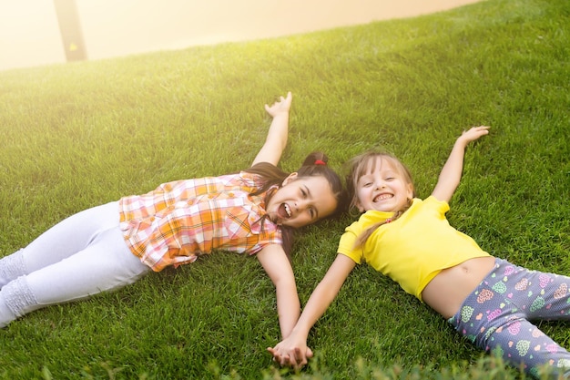 Portret van twee kleine meisjeszusters die vechten op de achtertuin van het huis. Vrienden meisjes plezier. Lifestyle openhartig familiemoment van broers en zussen die ruzie maken om samen te spelen.