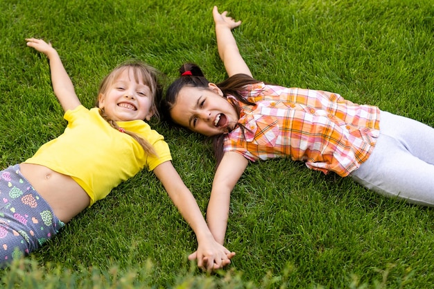 Portret van twee kleine meisjeszusters die vechten op de achtertuin van het huis. vrienden meisjes plezier. lifestyle openhartig familiemoment van broers en zussen die ruzie maken om samen te spelen.