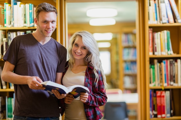 Portret van twee studenten die boek in de bibliotheek lezen