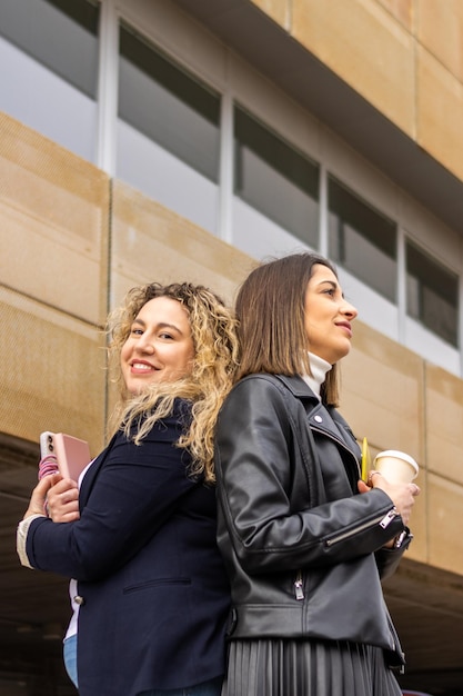 Portret van twee vrouwelijke ondernemers met gekruiste armen buiten een gebouw Portret van twee zakenvrouwen buiten een gebouw