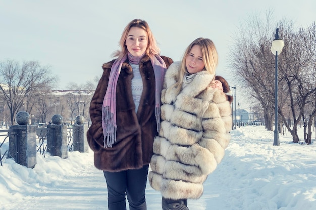 portret van twee vrouwelijke vriendinnen in winterbontjassen