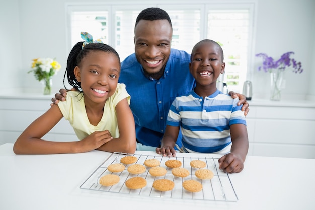 Portret van vader en kinderen met cookies op tafel