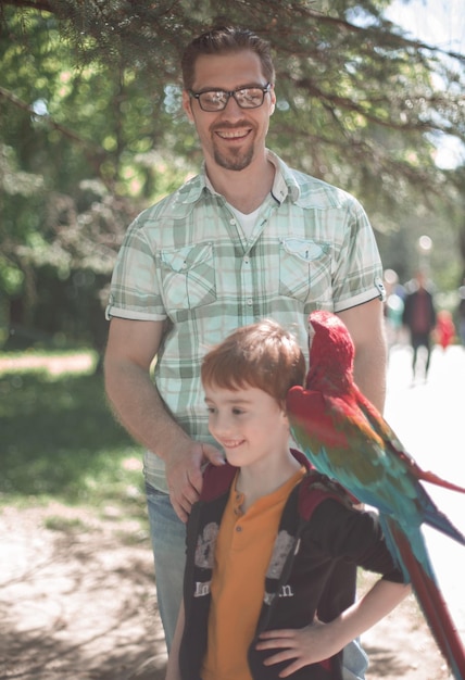 Portret van vader en zoon met ara papegaai