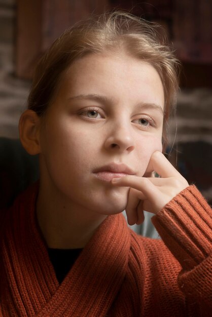 Portret van verdrietig tienermeisje in warme oranje trui thuis