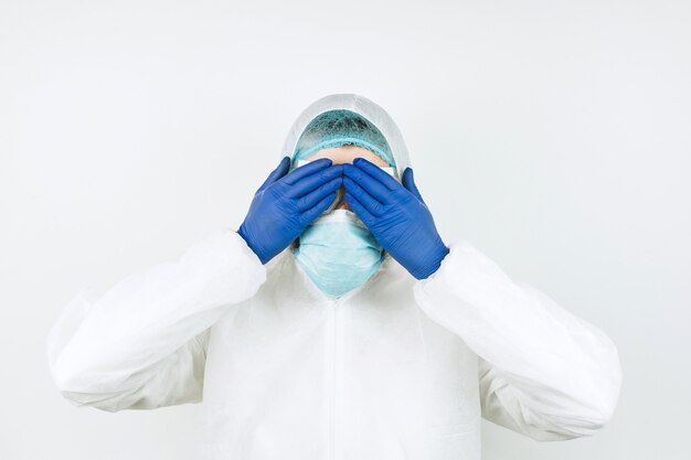 Portret van vermoeide arts na shift in het ziekenhuis. De dokter in beschermende kleding - bril, masker, handschoenen. De arts die patiënten behandelt met coronavirus. Covid-2019