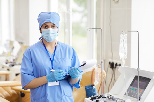 Portret van verpleegster in uniform en in beschermende kleding met lijsten van patiënten en tijdens het werken in het laboratorium