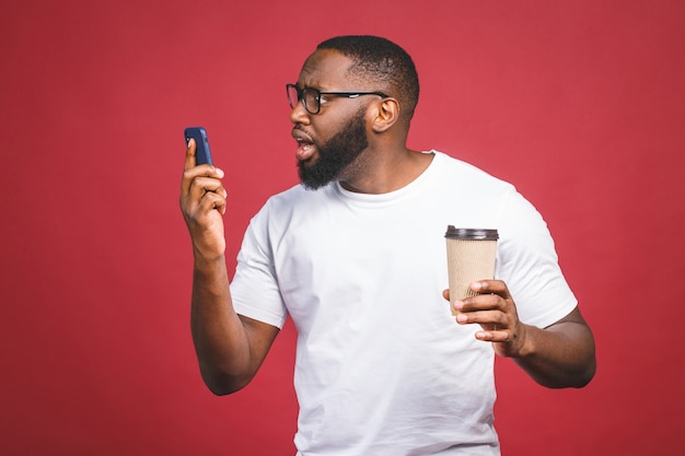 Portret van verrast knappe Afro-Amerikaanse man met mobiel