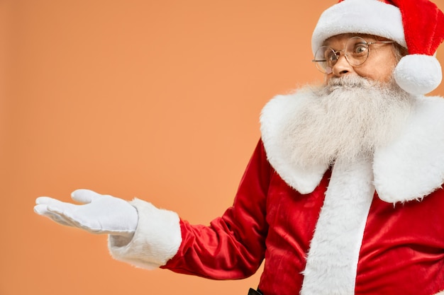 Portret van verraste Santa Claus met open palm in studio