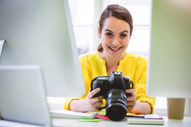 Portret van vertrouwen professional met digitale camera en computer op kantoor