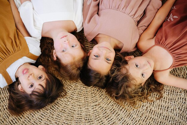 Foto portret van vier kinderen meisjes liggen op een mat top view