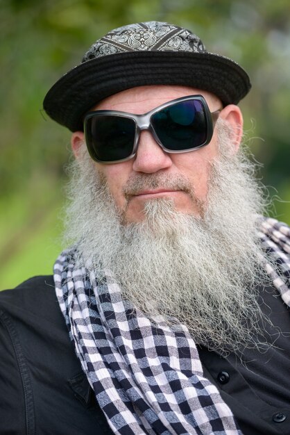 Foto portret van volwassen bebaarde hipster man in het park buitenshuis