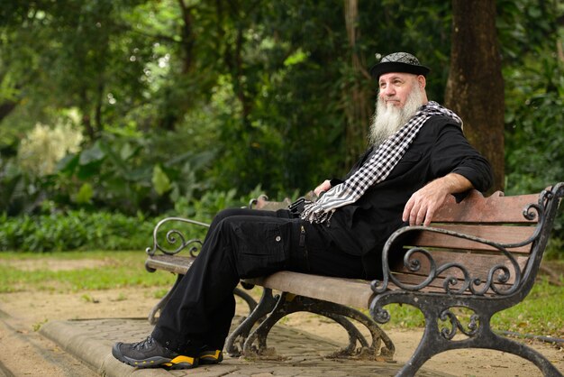 Portret van volwassen bebaarde hipster man in het park buitenshuis