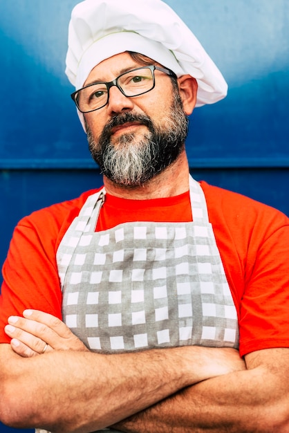 Foto portret van volwassen chef-kok hipster bebaarde man op zoek op camera en draag witte hoed concept van restaurant of café en mensen die eraan werken bril en rood blauw kleurenbeeld