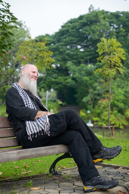 Portret van volwassen kale hipster man met lange baard in het park buiten