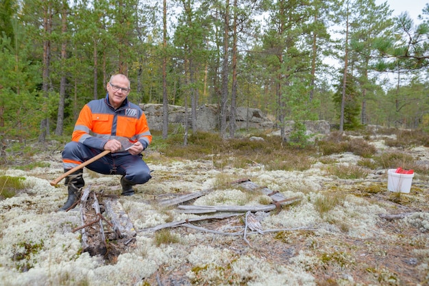 Portret van volwassen knappe Scandinavische man klaar om te oogsten in het bos buiten