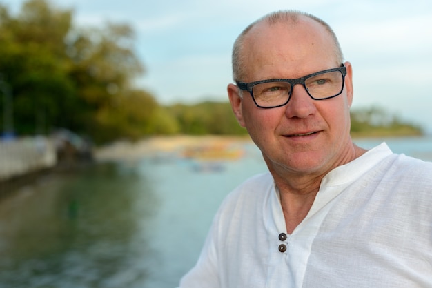 Portret van volwassen knappe toeristenmens tegen mening van het strand in openlucht