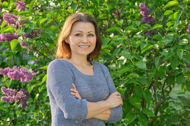 Portret van volwassen lachende vrouw met gekruiste armen